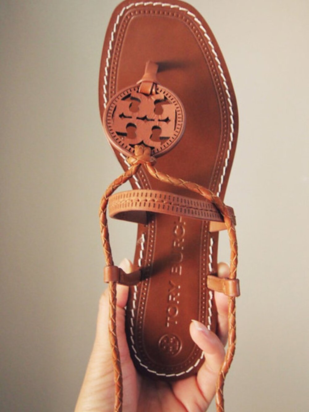 The Tory Burch Miller Braided Ankle-Wrap Sandal is a stylish flat sandal featuri